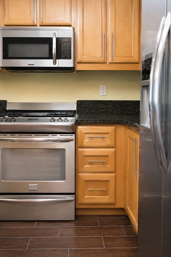 A kitchen with a stainless steel refrigerator, oven, and microwave.