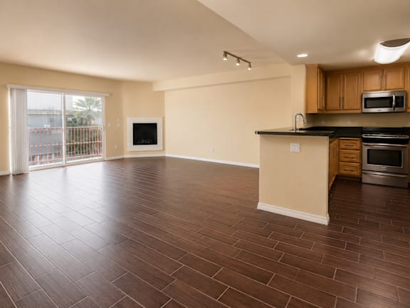 A kitchen with wooden floors and a countertop with a microwave and oven.
