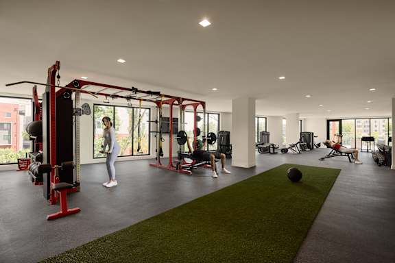 A woman is working out in a gym with a variety of equipment.