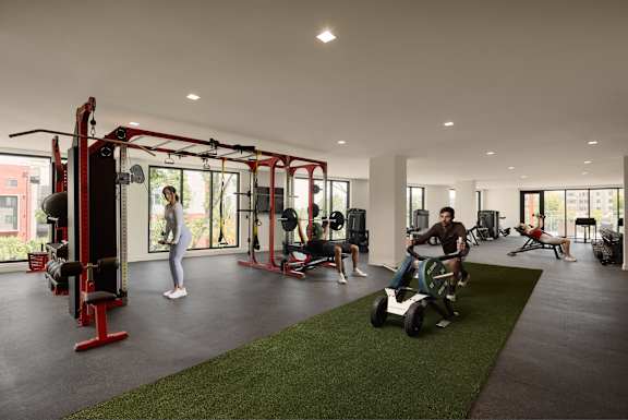 A gym with people working out and a green lawn.