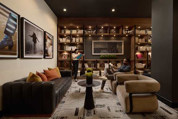 A man is sitting on a couch in a room with a coffee table in front of him.