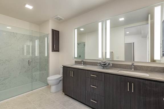 a bathroom with a large mirror and a toilet and a shower