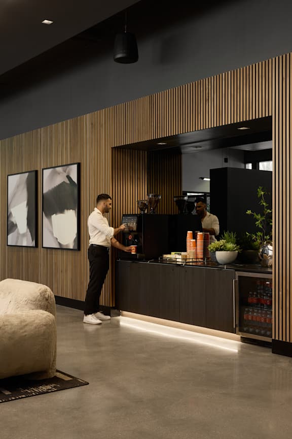 A person is standing at a counter with a plant on it.