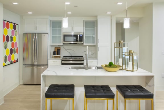a kitchen with a large island with three stools in front of it