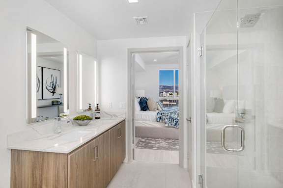 a bathroom with a shower and a sink and a bedroom