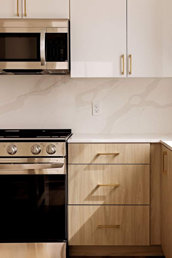 A modern kitchen with a black oven and wooden cabinets.