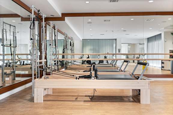 a row of weights machines in a room with mirrors