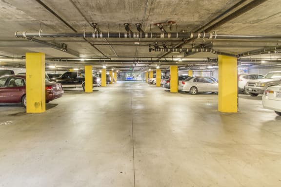 a parking garage with cars and yellow pillars at Dronfield Astoria Apartments, Sylmar, California, 91342