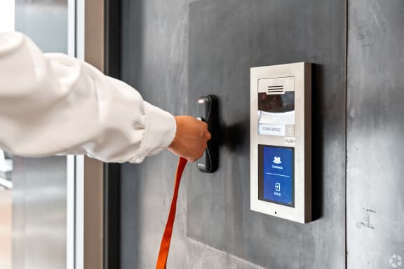 a man is pulling a red cord plugged into a door control panel