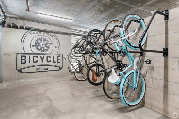 a group of bikes hanging on a wall in a bike garage