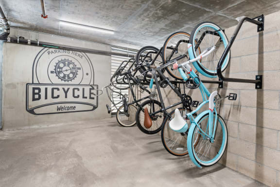 a group of bikes hanging on a wall in a bike garage
