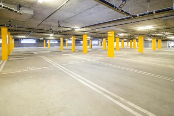 an empty parking garage with yellow pillars in it  at  Le Blanc Apartments, Canoga Park, California, CA