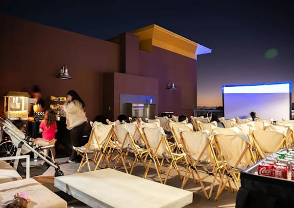 A room with a screen and chairs is set up for an event.