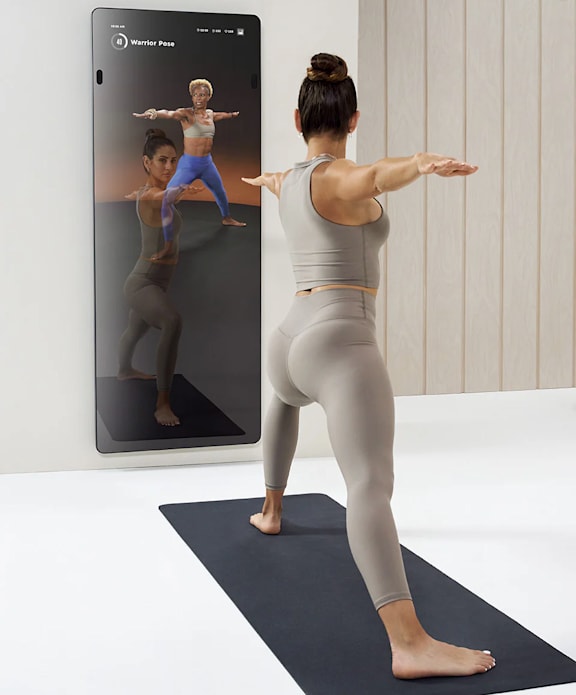 a woman standing in front of a mirror doing a yoga pose with her arms out