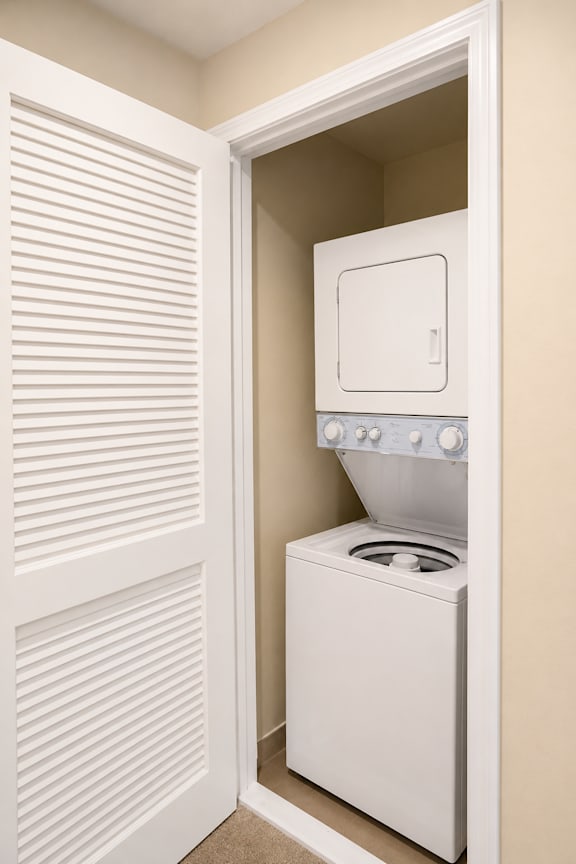 A white washing machine is in a small alcove.