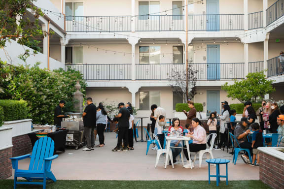 a group of people sitting at tables on a patio  at  Le Blanc Apartments, Canoga Park, California, CA