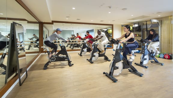 a group of people riding exercise bikes in a gym
