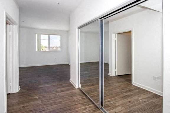 A room with a sliding glass door and wood flooring.
