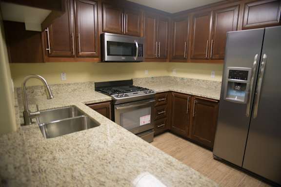 A kitchen with brown cabinets and stainless steel appliances.