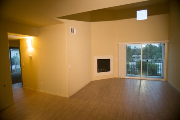 A room with a fireplace and sliding glass doors.
