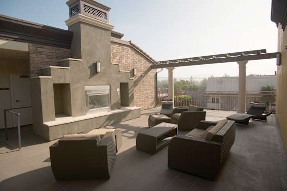 A patio with a fireplace and couches.