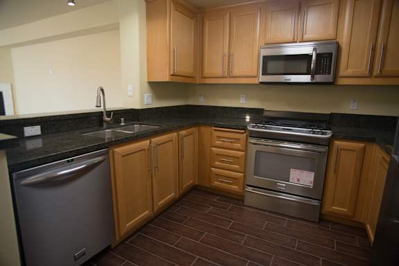 A kitchen with wooden cabinets and a black counter top.