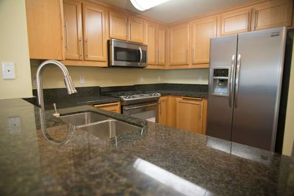 A kitchen with granite countertops and stainless steel appliances.