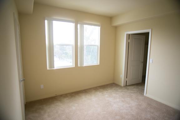 A room with a carpeted floor and a door.