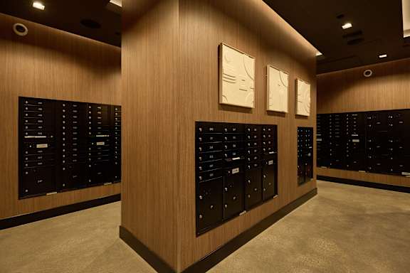 A wall of black panels with white drawers and a wooden panel with three white drawers.