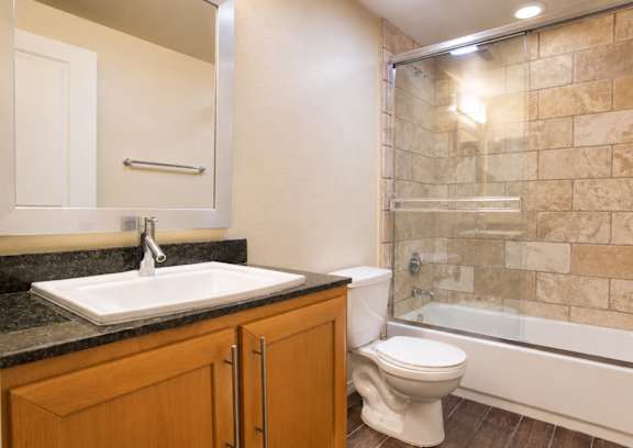 A bathroom with a sink, toilet and tub.