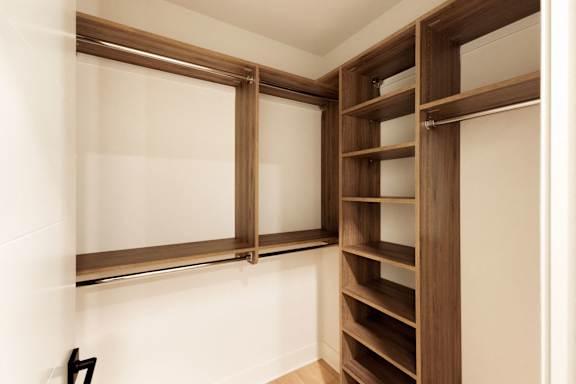 A brown shelving unit with glass doors is mounted on a white wall.