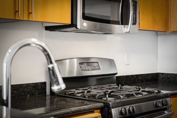 a kitchen with a stove top oven next to a microwave