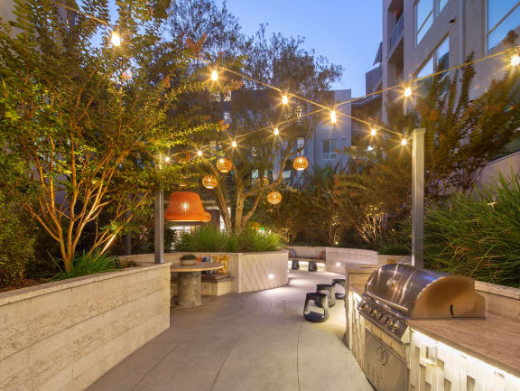 a patio with a barbecue grill and lights