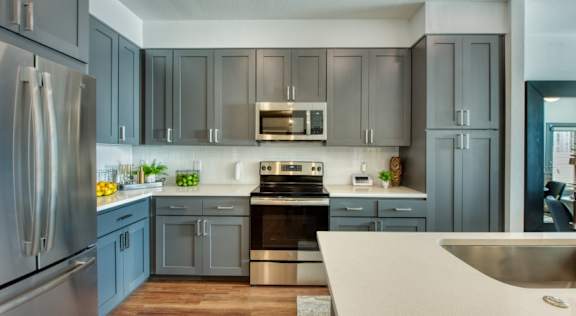 Elevation San Tan&#x27;s modern kitchen with a stainless steel refrigerator and a stove top oven.