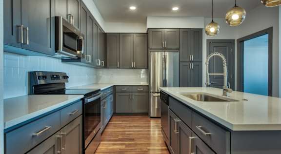 Large kitchen with gray cabinets and quartz countertops at Elevation SanTan