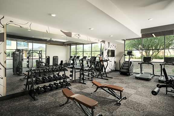 A gym with a variety of equipment including weights and treadmills.at Huxley Scottsdale, Arizona