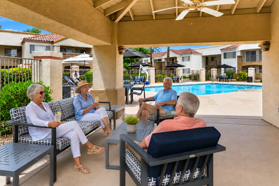Four people sitting on a patio.