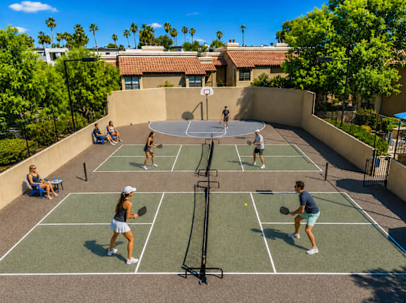 A group of people playing tennis on a court.