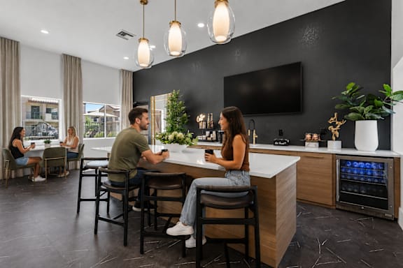 A modern kitchen with a couple sitting at the island.
