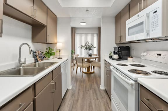 A kitchen with brown cabinets and white appliances.