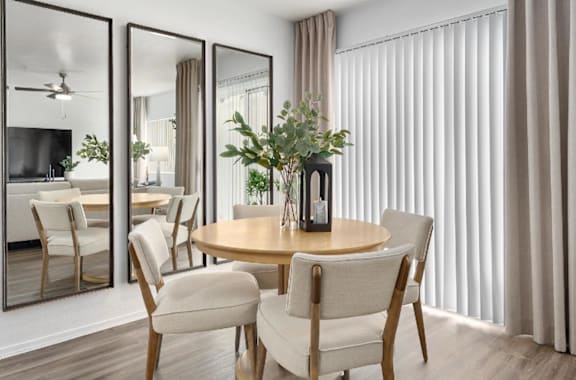 A dining room with a round table and chairs.