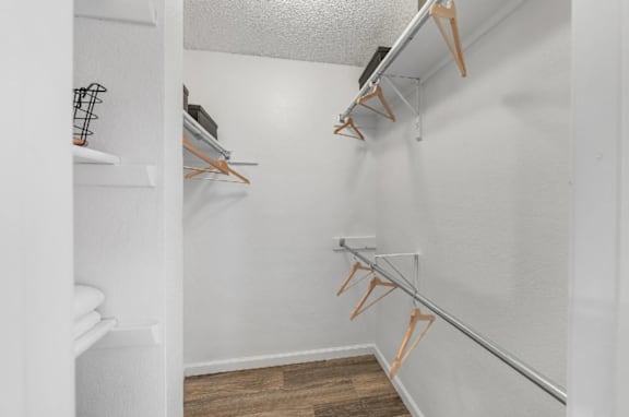 A white closet with clothes hangers.