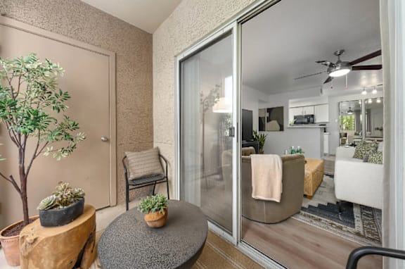 A living room with a glass door leading to a balcony.