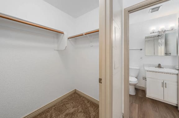 A white bathroom with a toilet, sink, and a mirror.