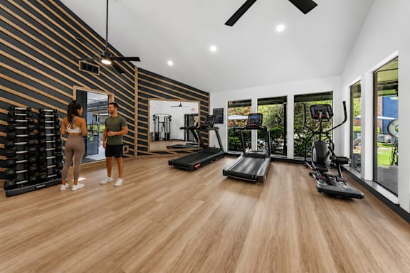 A gym with a woman and a man working out.