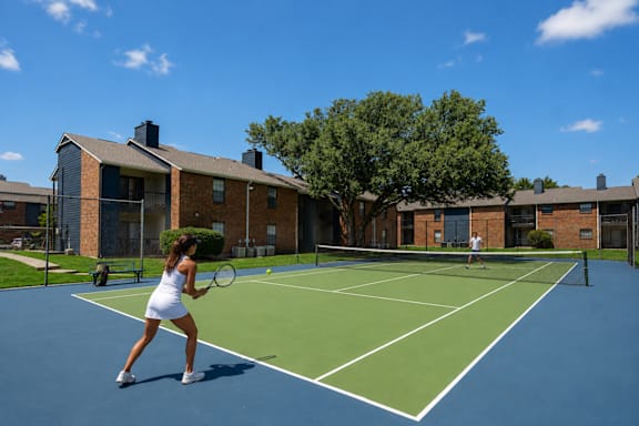 A woman is playing tennis on a blue court.