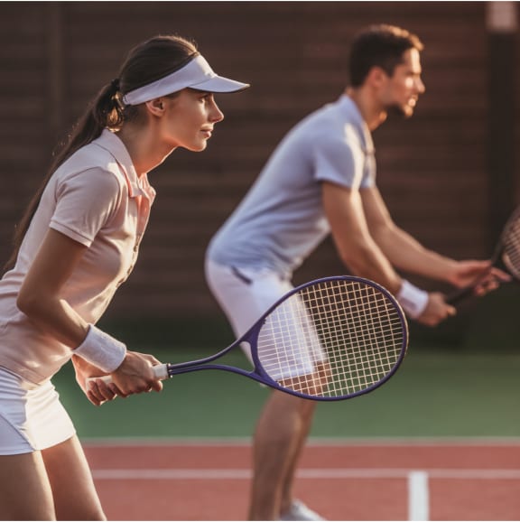 a young man and a young woman playing tennis