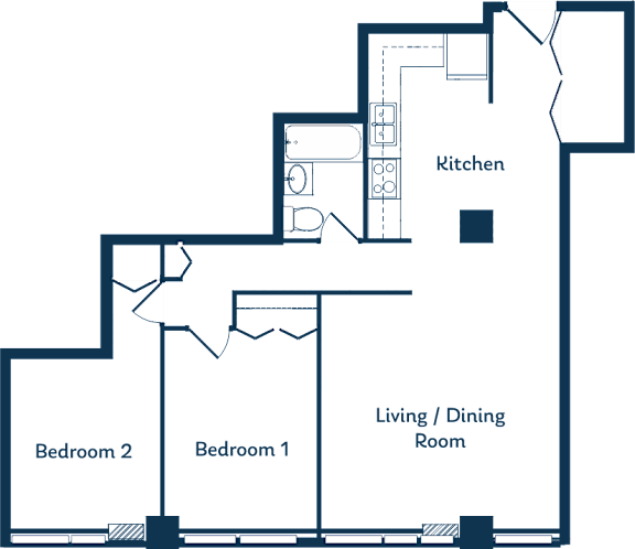 A floor plan of a house with a kitchen, two bedrooms, and a living/dining room.