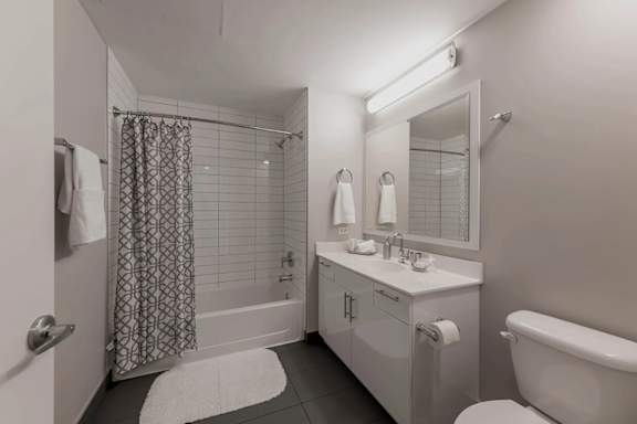 A white bathroom with a shower curtain and a white tub.
