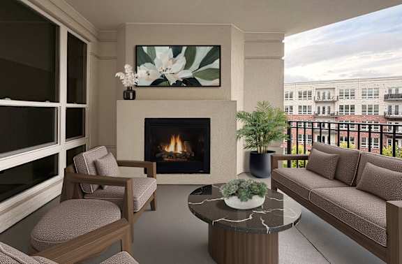 Spacious covered balcony with gas fireplace and scenic views of a beautifully landscaped courtyard at Xenia Apartments in Golden Valley Minnesota